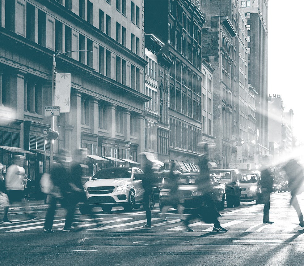 People walking across busy downtown intersection.