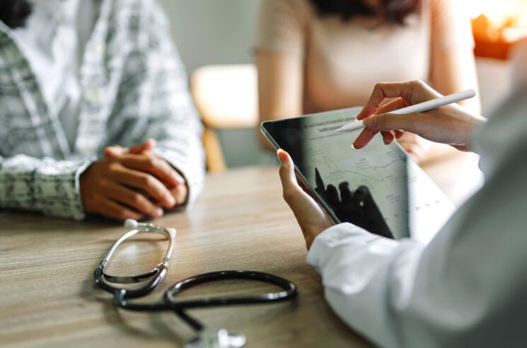 Patient and spouse listening to doctor at desk