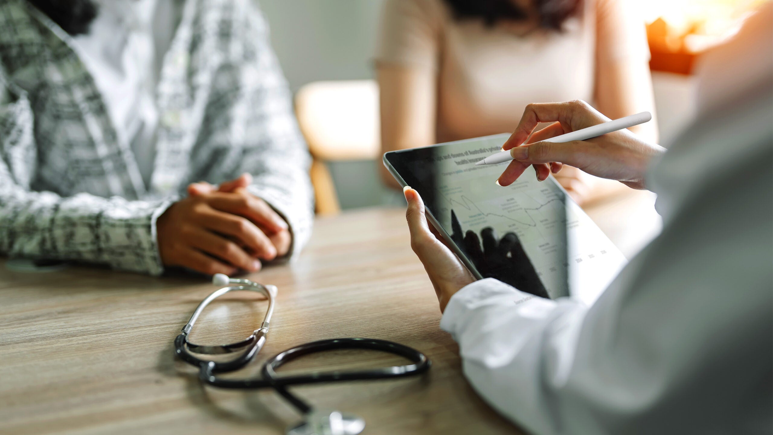 Patient and spouse listening to doctor at desk