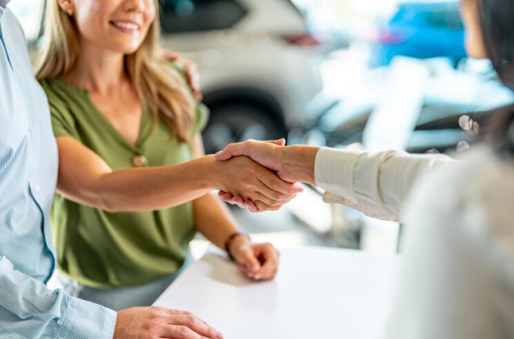 Female customer shaking hands with saleswoman
