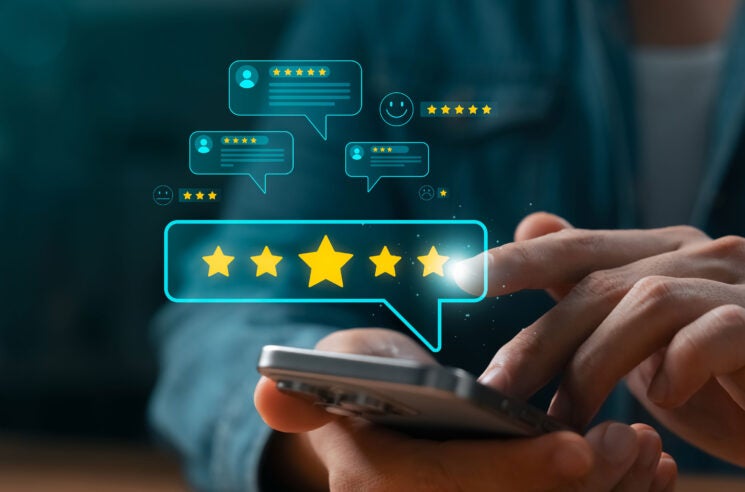 Hand using phone to leave a review