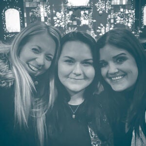 Three company friends smiling at holiday party