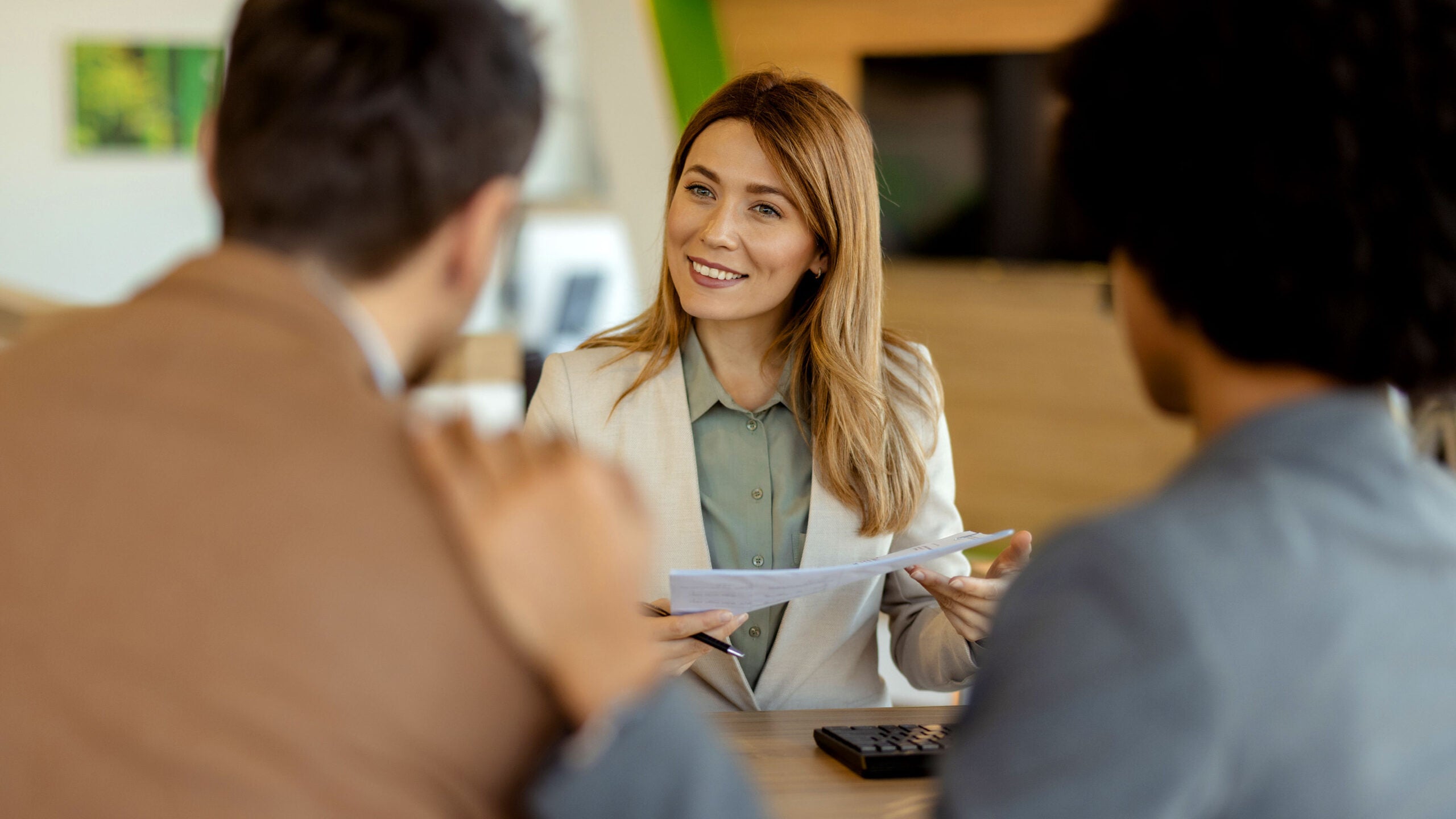Woman at desk helping buyers with paperwork