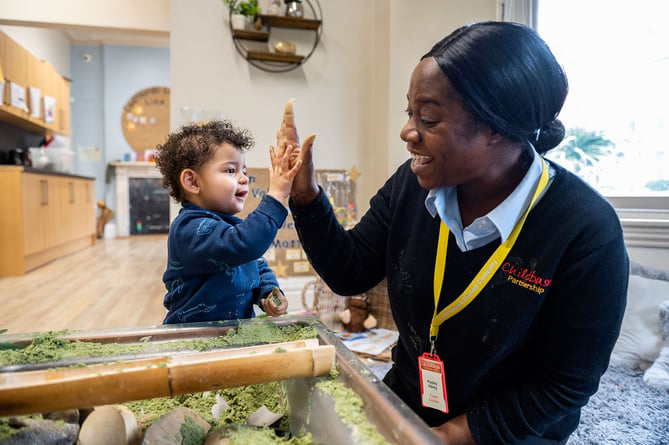 Childbase worker and child at craft table